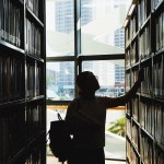 A student looks at books in a library.