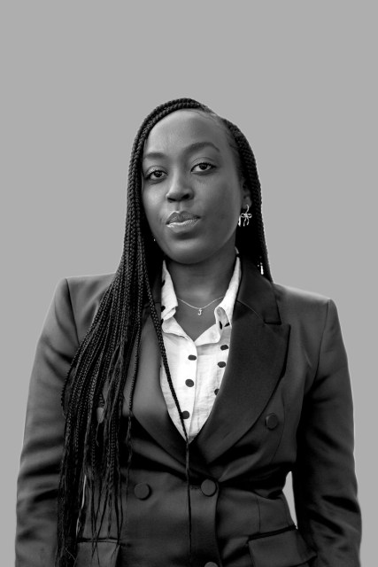 A portrait of Joy Ngugi in a suit.